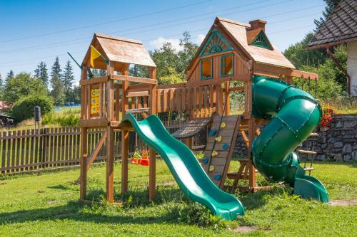 a playground with a slide and a house at Hotel Leyla in Frymburk