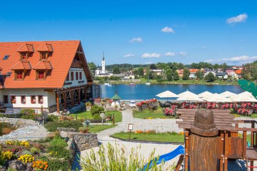 a view of a building with a garden and a lake at Hotel Leyla in Frymburk
