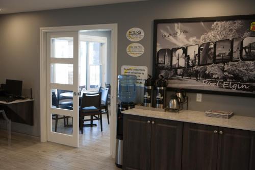 a dining room with a bar and a table with wine bottles at Super 8 by Wyndham Port Elgin in Port Elgin