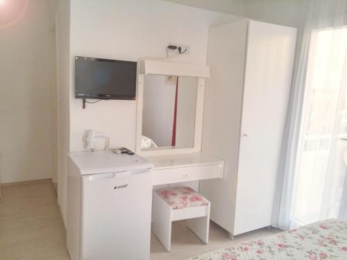 a white bathroom with a sink and a mirror at Parla Apart Hotel in Cesme