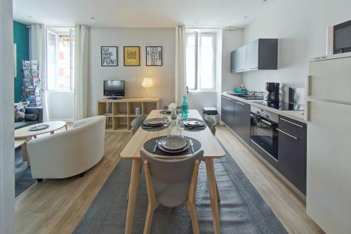 a kitchen and living room with a table and chairs at Les Salorges in Le Croisic