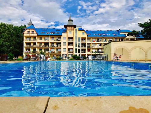 a large swimming pool in front of a hotel at Apartamenty Platinum in Łukęcin