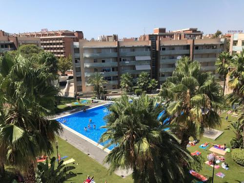an aerial view of a resort pool with palm trees at Saval Spa Aqquaria Family Complex in Salou
