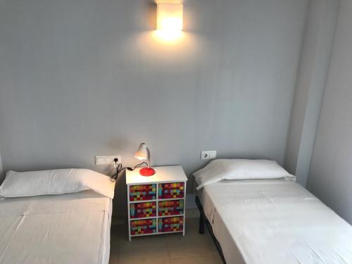 a room with two beds and a table with a lamp at Saval Spa Aqquaria Family Complex in Salou