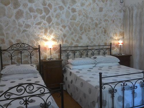 モノーポリにあるTrullocarluccioのベッドルーム1室(ベッド2台、壁に照明2つ付)