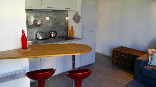 une cuisine avec un comptoir et deux tabourets rouges dans l'établissement Studio Lille-Republique, à Lille