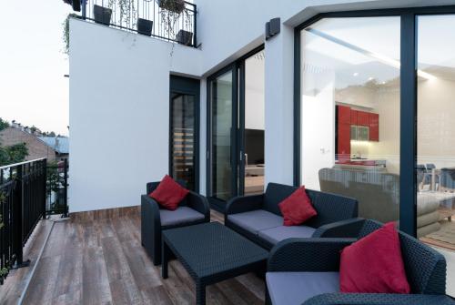 a patio with two couches and red pillows at BA Apartments in Sarajevo