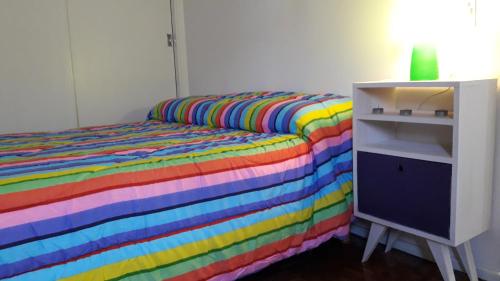 1 dormitorio con cama de arco iris y armario blanco en Distrito Palermo Apartment en Buenos Aires
