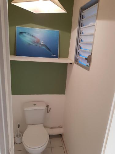 a bathroom with a toilet and a picture of a fish at Maison BLEU CORAIL in Bouillante