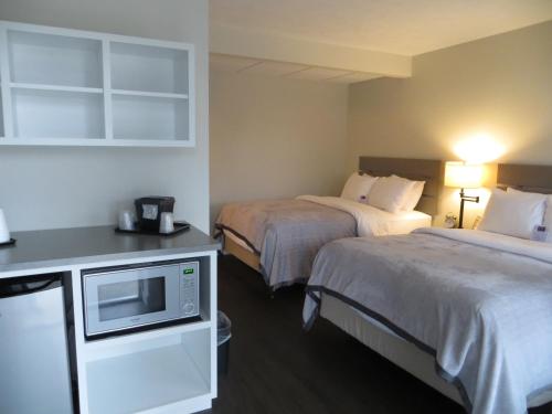 Habitación de hotel con 2 camas y microondas en Brio Beach Inn, en Traverse City