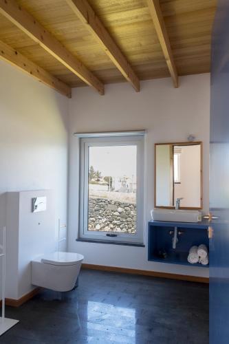 a bathroom with a tub and a sink and a window at Lofts Azul Pastel in Horta