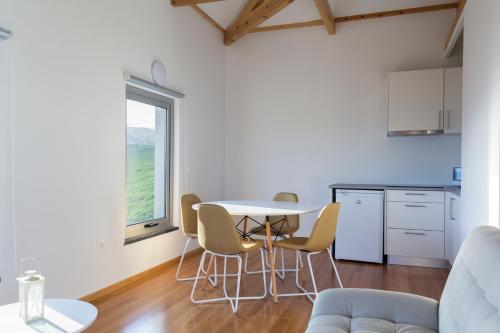 a kitchen with a table and chairs in a room at Lofts Azul Pastel in Horta