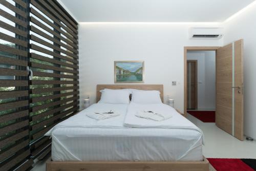 a bedroom with a large bed with white sheets at BA Apartments in Sarajevo