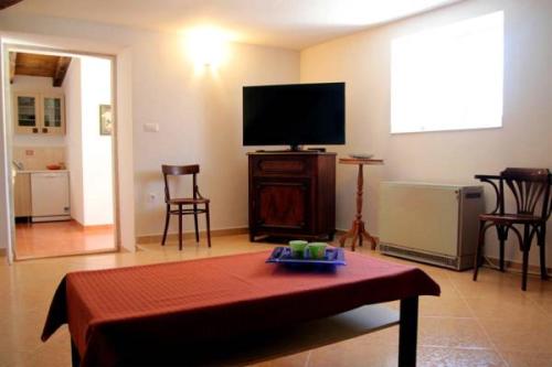 a living room with a flat screen tv and a table at Casa Eufemia in Marasi
