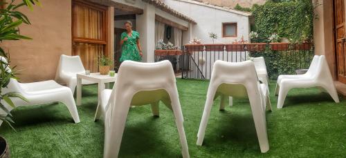 a group of chairs and a woman standing in a yard at Hotel Almunia in Caravaca de la Cruz