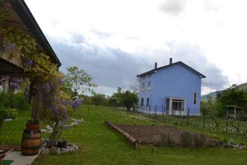a white house on a hill with a yard at Ka' Tari in Ponte nellʼAlpi