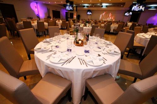 a dining room with a white table and chairs at Dña Monse Hotel Spa & Golf in Torrevieja