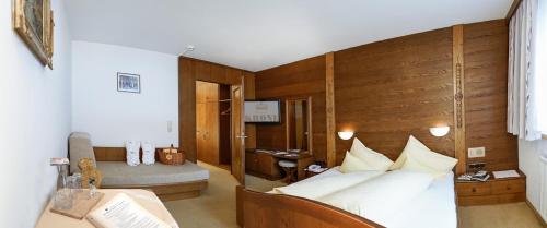 ein Schlafzimmer mit einem Bett und einem Schreibtisch in einem Zimmer in der Unterkunft Sporthotel Krone in Schoppernau