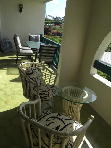 a patio with chairs and a glass table on a balcony at Bay View in St Thomas