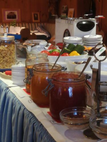 a table topped with jars of honey and vegetables at Landgasthof Santner in Thalgau