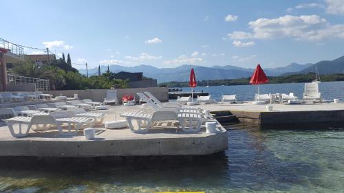 a group of chairs and tables on a dock in the water at Apartments Klakor PS in Tivat