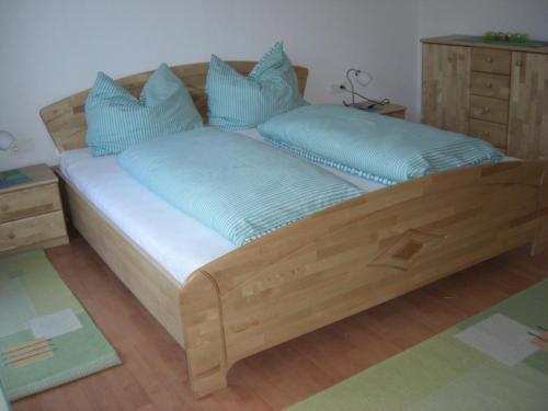 un letto in legno con cuscini blu in una stanza di Ferienwohnung Prader a Innsbruck
