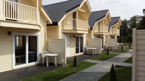 a row of houses with chairs and tables on a lawn at Perłowe Wzgórze in Ustronie Morskie