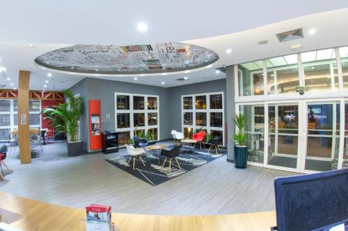 a lobby of a store with chairs and tables at ibis Araçatuba in Araçatuba