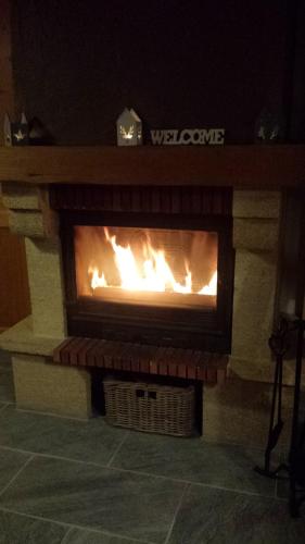 a fireplace with a fire inside of it at Clos du Pre - Chalet Chaleur in Oz