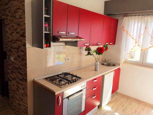 a kitchen with red cabinets and a stove at Apartment Lovre in Split