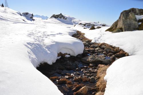 a stream covered in snow next to a mountain at Clos du Pre - Chalet Chaleur in Oz