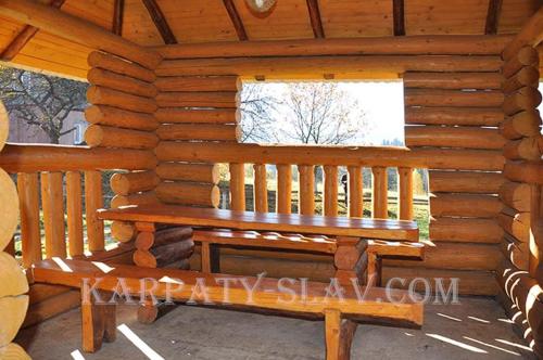 a wooden bench in a log cabin with a window at Zacharovany Karpaty in Slavske