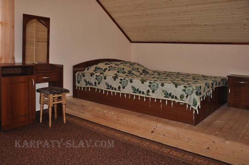 a bedroom with a large bed and a wooden desk at Zacharovany Karpaty in Slavske
