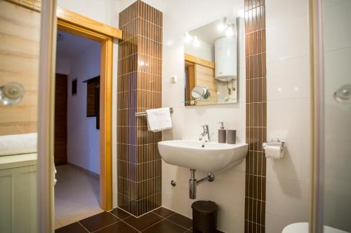 La salle de bains est pourvue d'un lavabo blanc et d'une douche. dans l'établissement Apartman Irena, à Pula