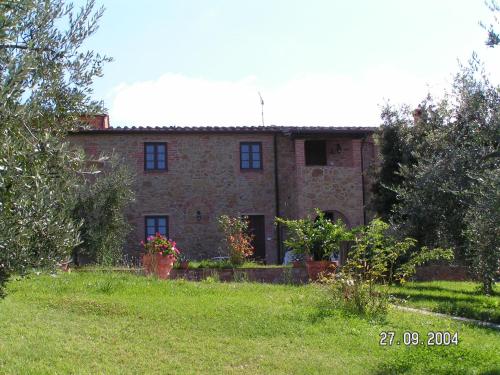 an old brick house in the middle of a yard at Borgo Di Collelungo in Montaione