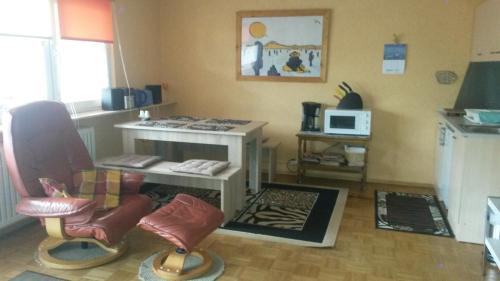 ein Wohnzimmer mit Stühlen, einem Tisch und einer Mikrowelle in der Unterkunft Ferienwohnung Mau in Pirmasens
