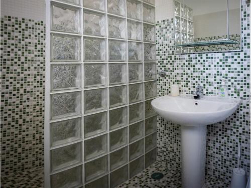 a bathroom with a sink and a glass wall at Vivenda Jardim Mar Algarve Porches in Porches