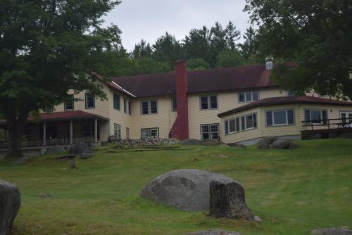 a large white house with a red chimney at The Long View Lodge in Long Lake