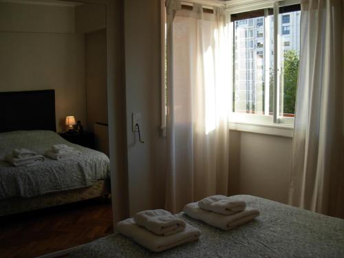 2 toallas en 2 camas en una habitación con ventana en Depto Recoleta Central en Buenos Aires