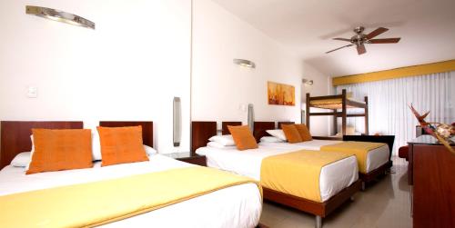 a bedroom with two beds and a ceiling fan at Atlantis Plaza Hotel Cúcuta in Cúcuta