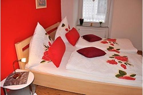 a bedroom with a bed with red walls at Moselwinzerhaus in Bruttig-Fankel