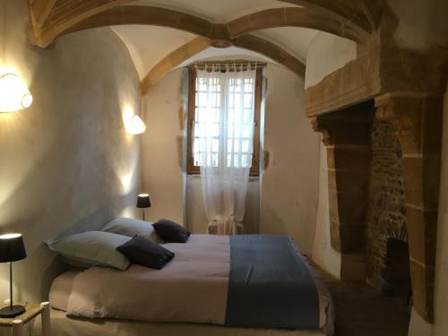 - une chambre avec un lit dans une pièce dotée d'une cheminée dans l'établissement Manoir au sein du village, à Saint-Haon-le-Châtel