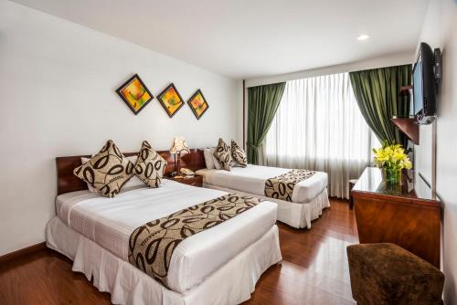 Hotel Platinum Suite في بوغوتا: غرفة فندقية بسريرين وتلفزيون بشاشة مسطحة