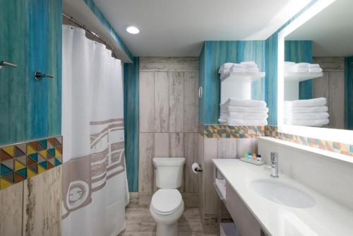 ein Badezimmer mit einem WC, einem Waschbecken und einem Spiegel in der Unterkunft Margaritaville Island Inn in Pigeon Forge