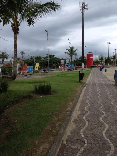 a park with palm trees and a cobblestone sidewalk at Pousada Bertioga in Bertioga