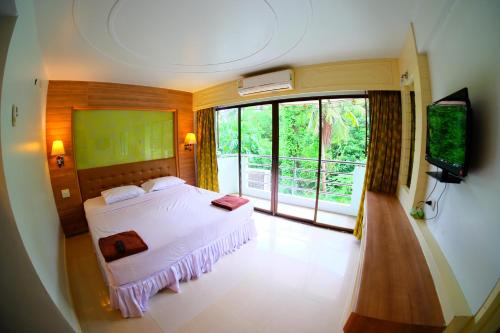 a bedroom with a white bed and a television at Aonang Top View in Ao Nang Beach