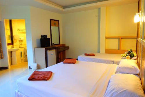 a hotel room with three beds and a mirror at Aonang Top View in Ao Nang Beach