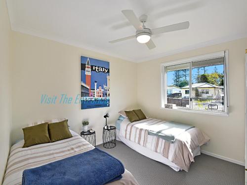 a bedroom with two beds and a window at The Nautical House in The Entrance