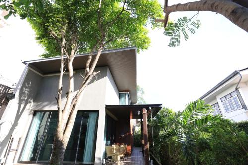a home with a tree in front of it at The White Elephant Home in Chiang Mai