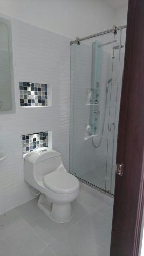a bathroom with a toilet and a glass shower at Casa Quinta Santana in Melgar